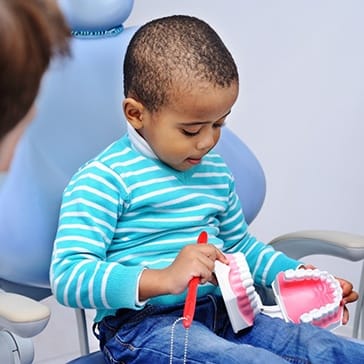 child learning about how to brush their teeth with their children’s dentist in Duncanville