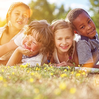 friends playing outside and laying in the grass