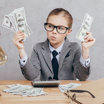 Child wearing glasses holding paper money and looking confused 