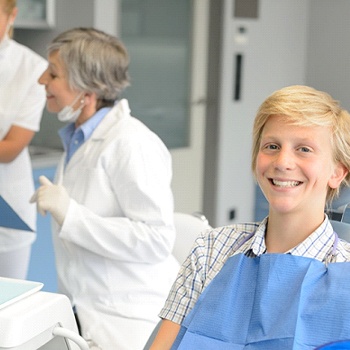 A teenage boy sits in the dentist’s chair waiting for his checkup