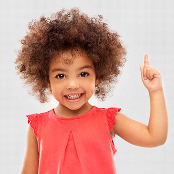 A little girl wearing a red blouse, pointing upward, and smiling after seeing her pediatric dentist in Duncanville