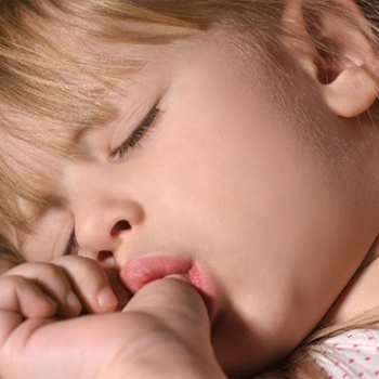 A little girl sucking her thumb while asleep