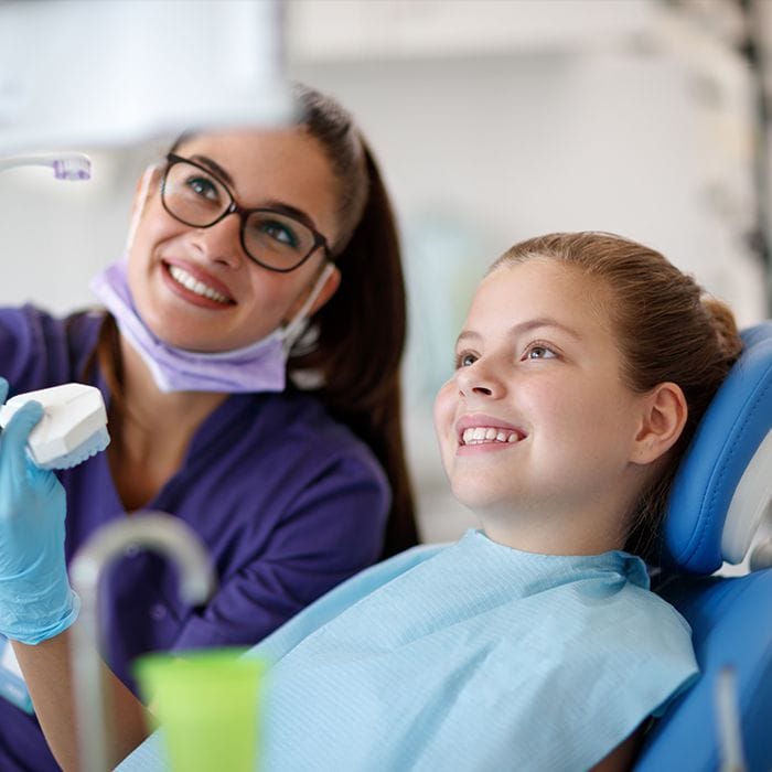 Child and dentist looking at chairside computer monitor