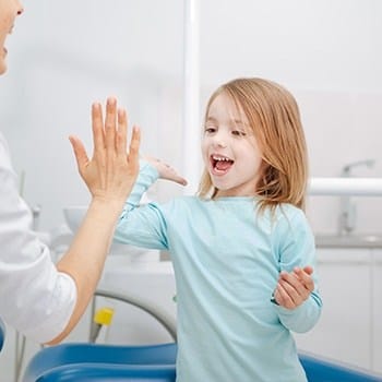 Child giving dentist a high five