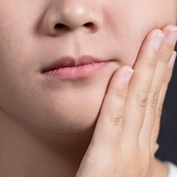 Closeup of child holding cheek