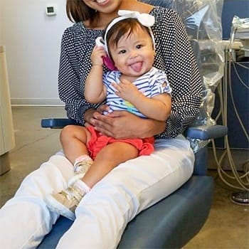 Little girl in dental chair sticking out her tongue