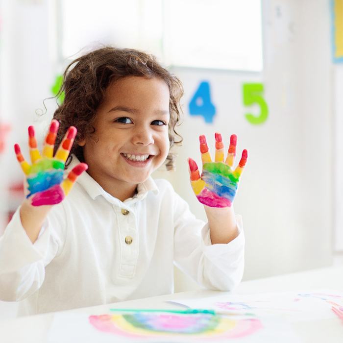 young child finger painting in class 