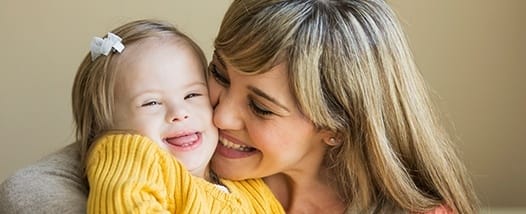 Mother hugging her laughing daughter