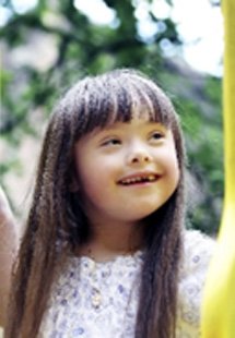 Closeup of child with special needs smiling on playground