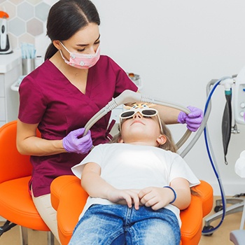 A dentist helping a young child with nitrous oxide aftercare