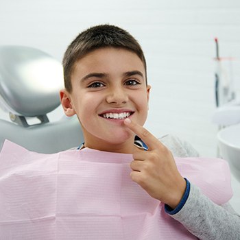 Young boy pointing to his smile