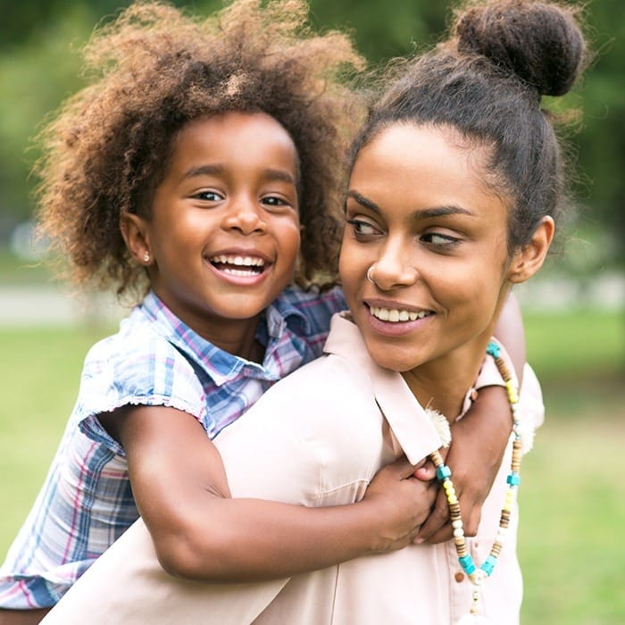 Smiling mother and daughter outdoors