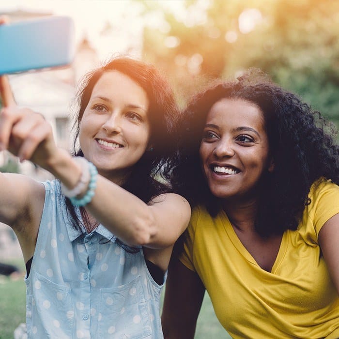 Two young women taking a selfie outdoors