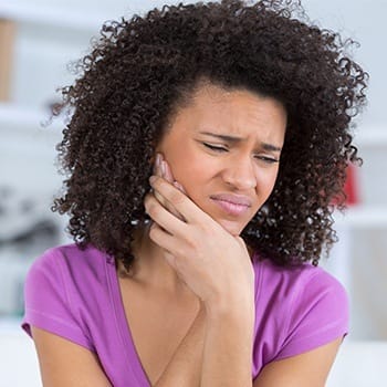 Woman in pain holding jaw