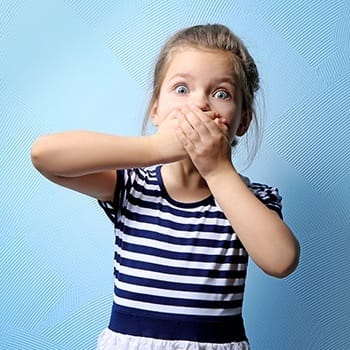 Little girl covering her mouth