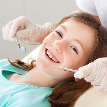 A young girl smiling while preparing to see her pediatric dentist in Duncanville