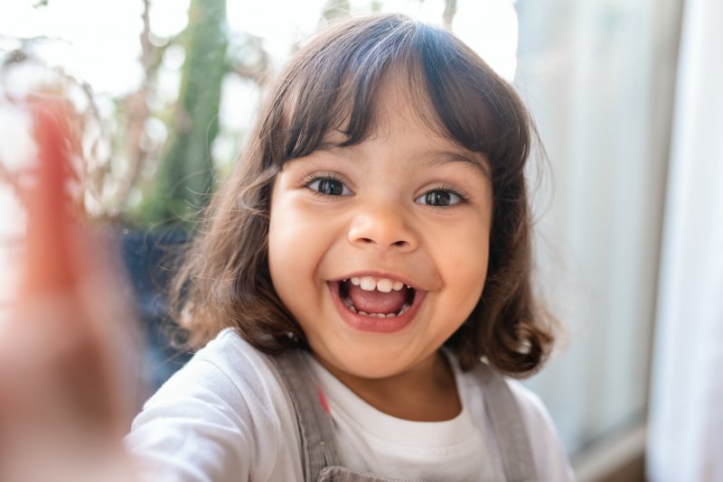 Child standing outside and smiling